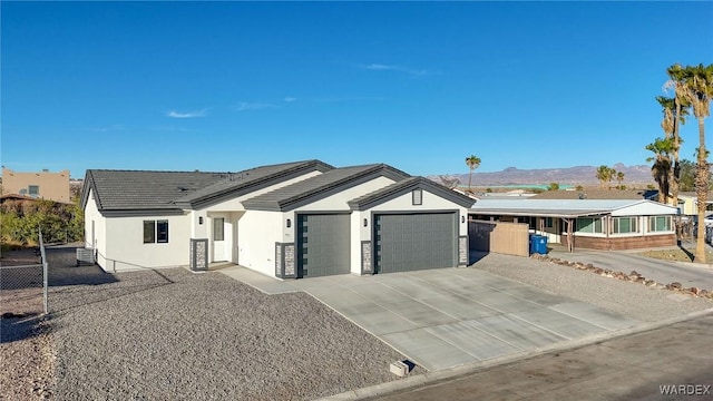 view of front of property with an attached garage, driveway, a mountain view, and stucco siding