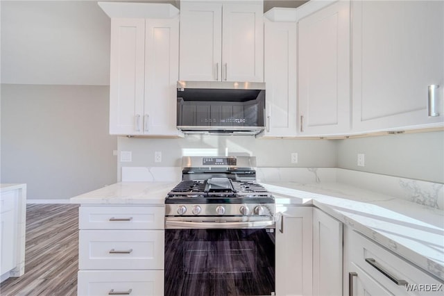 kitchen featuring gas range and white cabinets