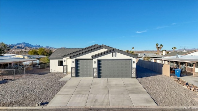 view of front of property featuring a mountain view, driveway, an attached garage, and stucco siding