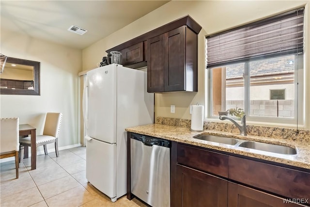 kitchen featuring visible vents, a sink, stainless steel dishwasher, light tile patterned floors, and dark brown cabinets