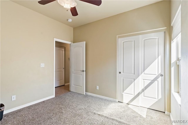 unfurnished bedroom featuring carpet flooring, a ceiling fan, and baseboards