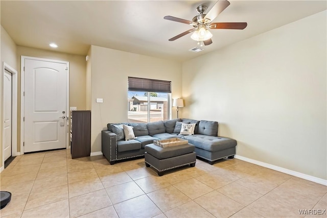 living area featuring light tile patterned floors, visible vents, baseboards, and a ceiling fan