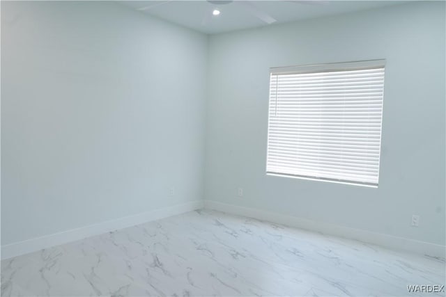 unfurnished room with marble finish floor, baseboards, and recessed lighting