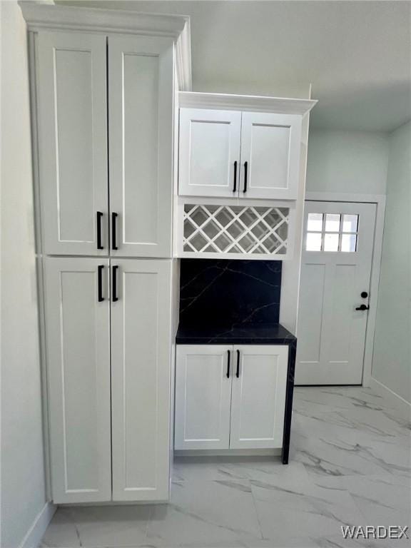 bar with marble finish floor and baseboards