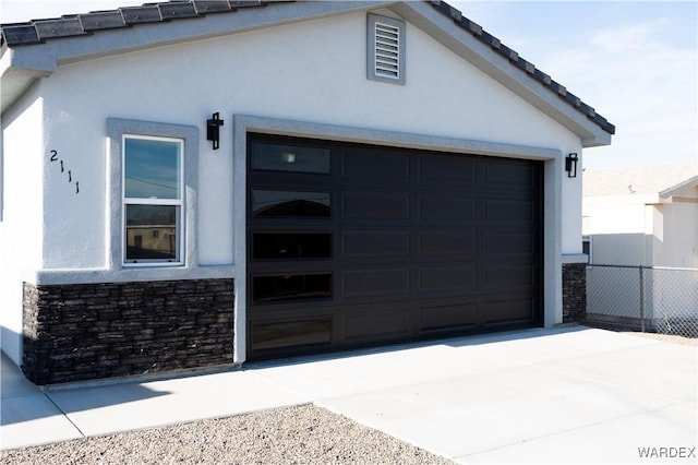 garage with driveway and fence