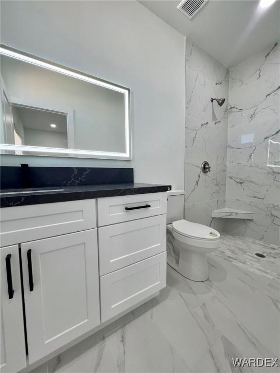 bathroom featuring marble finish floor, a marble finish shower, visible vents, toilet, and vanity