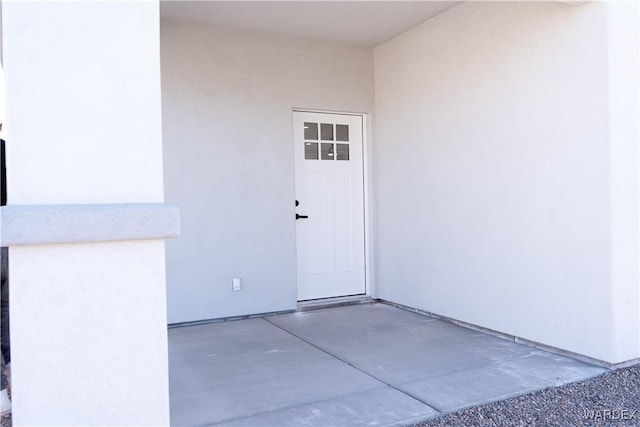 property entrance with a patio and stucco siding