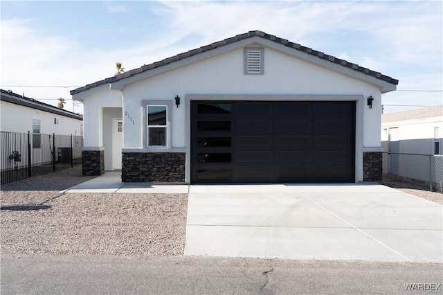 view of front of property featuring concrete driveway, fence, and stucco siding