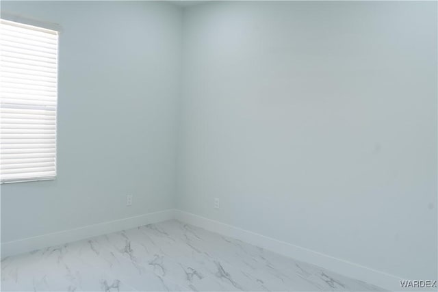 empty room with marble finish floor and baseboards