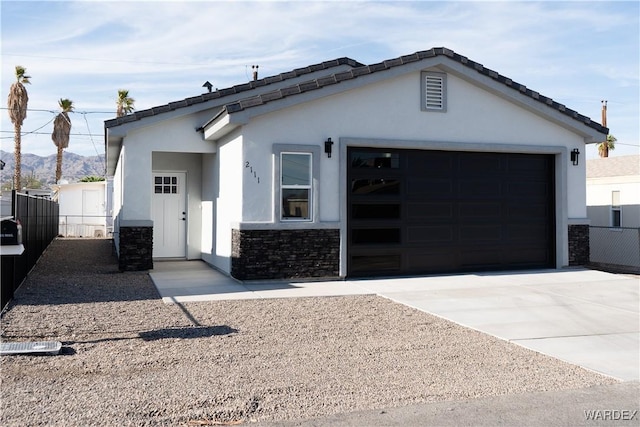 ranch-style home with concrete driveway, fence, and stucco siding