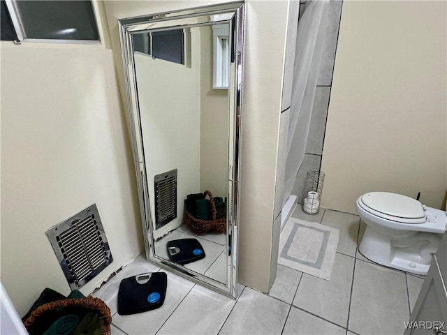 bathroom with toilet, a shower with curtain, and tile patterned floors