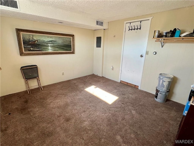 empty room with visible vents, dark carpet, and a textured ceiling