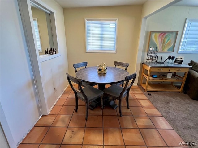 carpeted dining room with tile patterned flooring