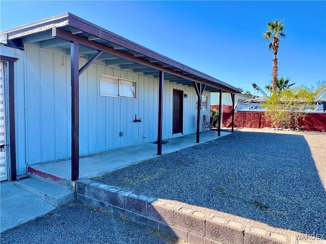 exterior space with fence, board and batten siding, and a patio