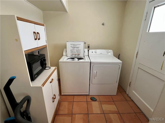 laundry room featuring separate washer and dryer, light tile patterned flooring, and cabinet space