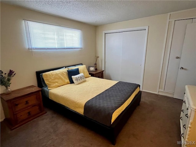 bedroom featuring dark carpet and a textured ceiling