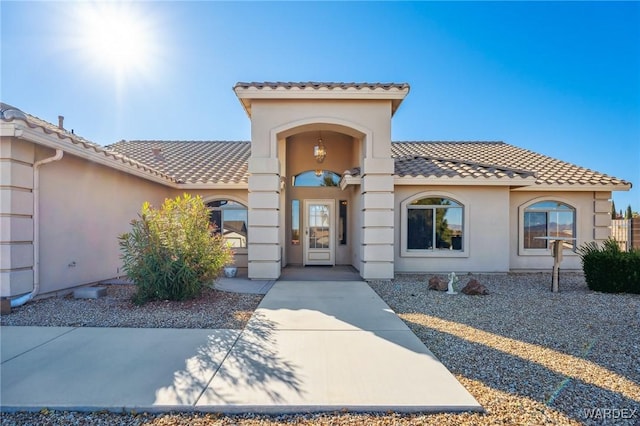 view of front of home with a tile roof and stucco siding