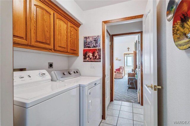 laundry room with light tile patterned floors, washer and clothes dryer, light carpet, and cabinet space