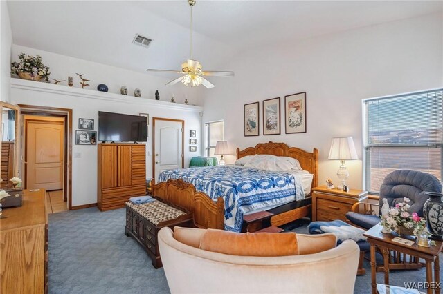 bedroom with lofted ceiling, ceiling fan, carpet flooring, visible vents, and a closet