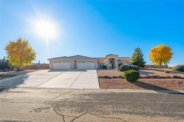 mediterranean / spanish house with a garage and concrete driveway