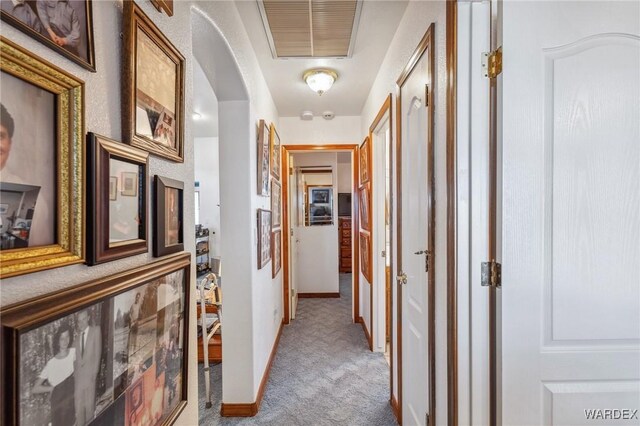 hall with visible vents and light colored carpet