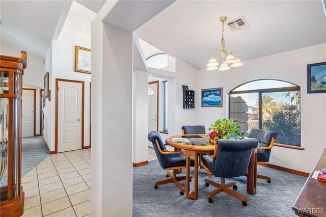 dining space featuring vaulted ceiling, light tile patterned flooring, visible vents, and light colored carpet