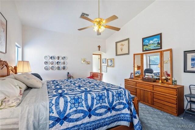 carpeted bedroom with ceiling fan, high vaulted ceiling, multiple windows, and visible vents