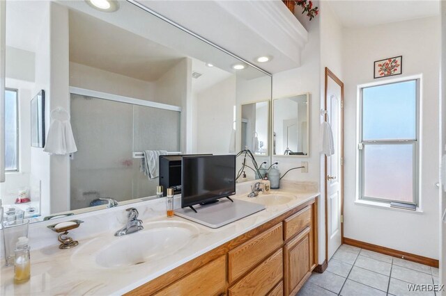 bathroom featuring double vanity, tile patterned flooring, baseboards, and a sink