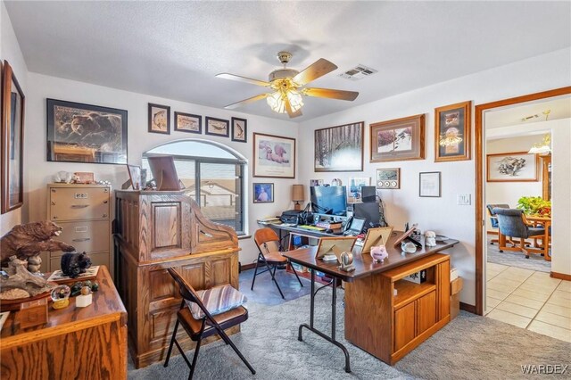 office space featuring ceiling fan, light tile patterned flooring, light colored carpet, visible vents, and baseboards