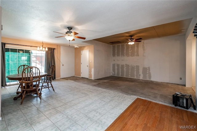 dining space with a textured ceiling and ceiling fan with notable chandelier