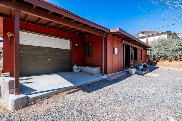 view of side of home featuring driveway and an attached garage