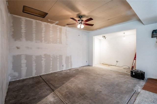 empty room with ceiling fan and concrete flooring