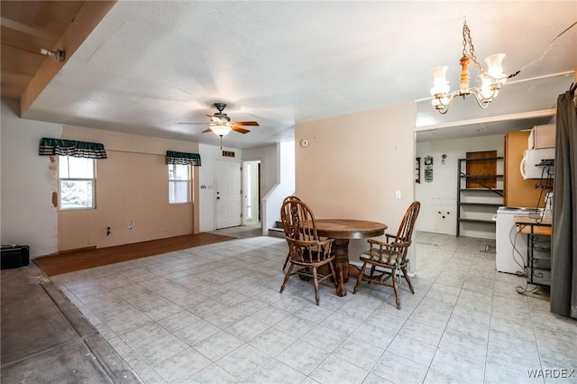 dining space featuring washer / dryer and ceiling fan with notable chandelier