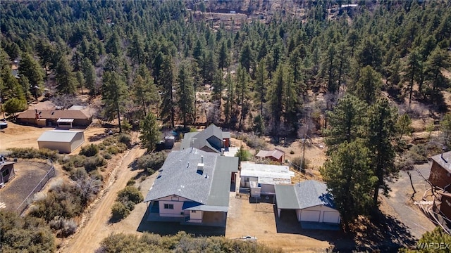 birds eye view of property featuring a forest view