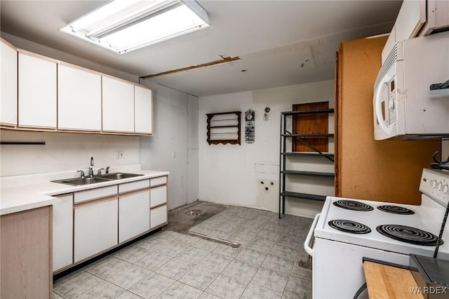 kitchen with light countertops, white appliances, white cabinets, and a sink