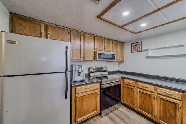 1800 Clubhouse Dr Unit H70, Bullhead City, AZ 86442 - kitchen featuring stainless steel appliances, recessed lighting, dark countertops, light wood-type flooring, and brown cabinetry