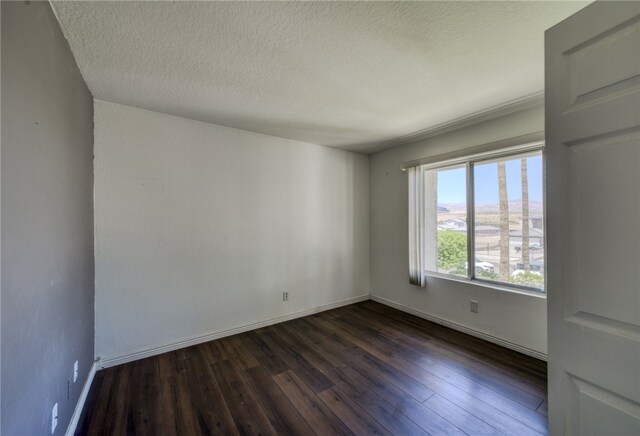 1800 Clubhouse Dr Unit H70, Bullhead City, AZ 86442 - unfurnished room with dark wood-style floors, baseboards, and a textured ceiling