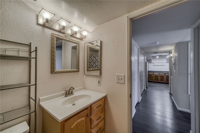 1800 Clubhouse Dr Unit H70, Bullhead City, AZ 86442 - bathroom with vanity, a textured wall, wood finished floors, toilet, and a textured ceiling