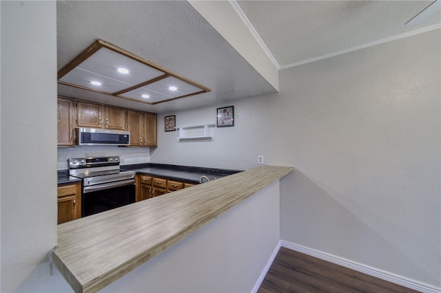 1800 Clubhouse Dr Unit H70, Bullhead City, AZ 86442 - kitchen with stainless steel appliances, recessed lighting, baseboards, dark wood-type flooring, and a peninsula