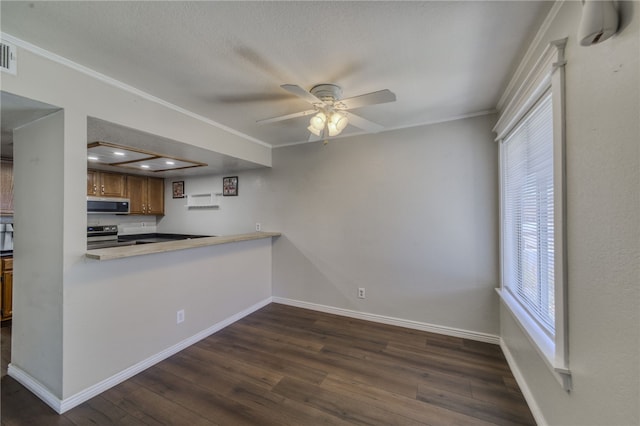1800 Clubhouse Dr Unit H70, Bullhead City, AZ 86442 - kitchen featuring appliances with stainless steel finishes, crown molding, dark wood finished floors, brown cabinetry, and ceiling fan