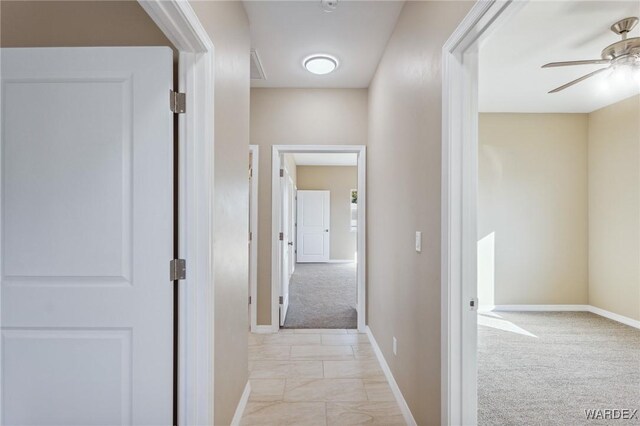 corridor with light colored carpet and baseboards