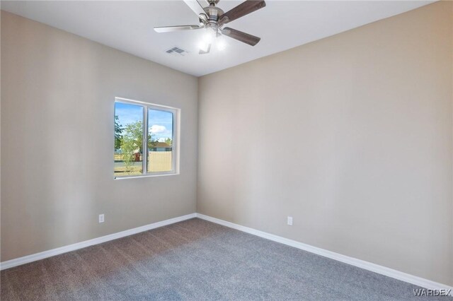 carpeted spare room with a ceiling fan, visible vents, and baseboards