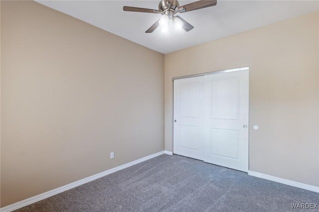 unfurnished bedroom with carpet, baseboards, ceiling fan, and a closet