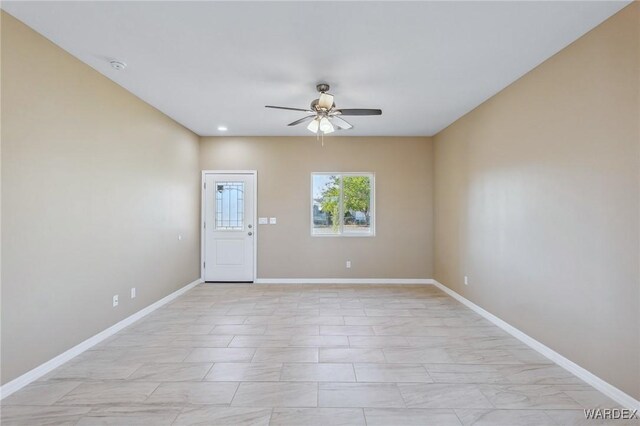 unfurnished room featuring baseboards and a ceiling fan