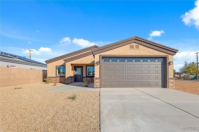 view of front of house featuring stucco siding, an attached garage, fence, stone siding, and driveway