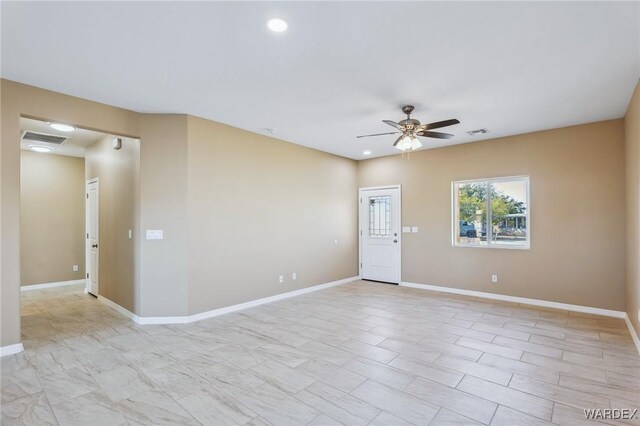 spare room with baseboards, visible vents, and a ceiling fan