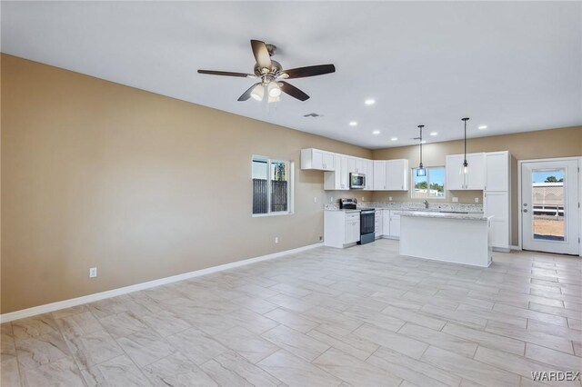 kitchen with stainless steel appliances, white cabinets, light countertops, and baseboards