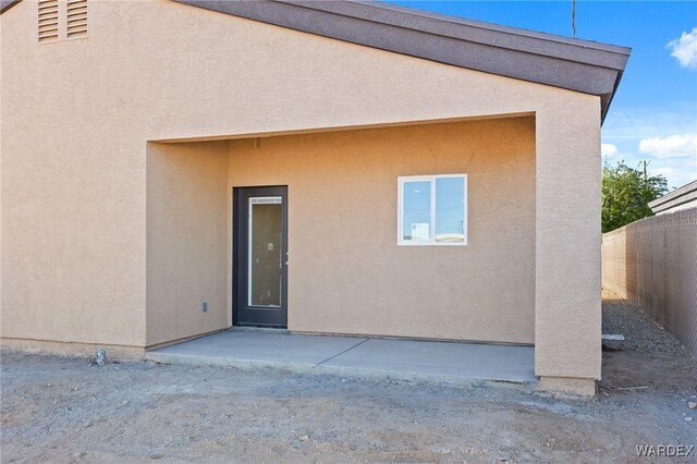 back of house featuring visible vents, fence, a patio, and stucco siding