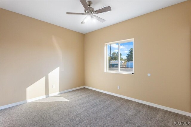 empty room with a ceiling fan, baseboards, and carpet flooring