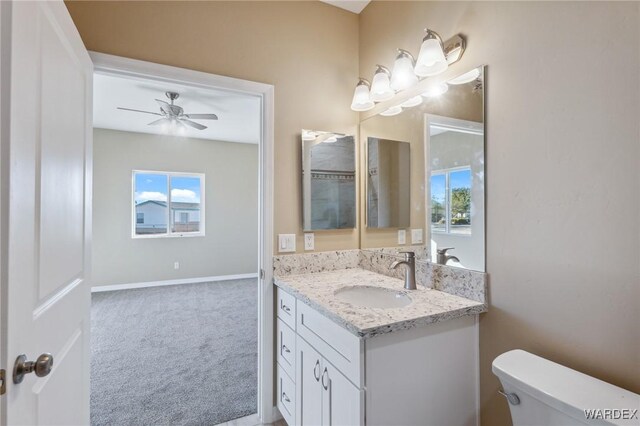 bathroom with toilet, baseboards, a ceiling fan, and vanity